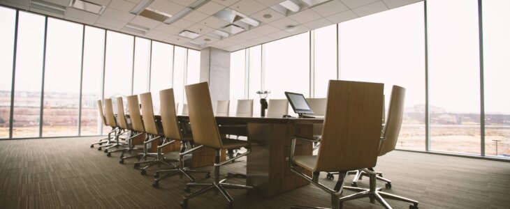 Empty and austere conference room with a long table and chairs