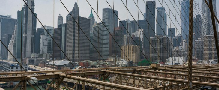 Skyline of NYC seen through Brooklyn Bridge cables.