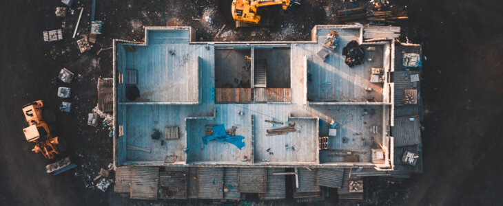 Drone footage of the inside of a house under construction surrounded by building equipment taken at sunrise in spring 2019