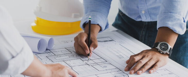 engineer meeting for an architectural project. working with partner and engineering tools working on blueprint architectural project at the construction site at desk in the office.